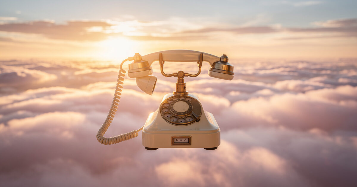 A vintage cream and brass rotary telephone above a sea of sunset clouds, its handset lifted and hanging in the air.
